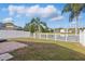 Well-maintained backyard with a charming patio, lush lawn, and a pristine white fence overlooking a tranquil pond at 13212 Briar Forest Ct, Orlando, FL 32828