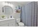 Stylish bathroom with a modern vanity, round mirror, decorative shelves, and a patterned shower curtain at 13212 Briar Forest Ct, Orlando, FL 32828