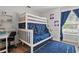 bedroom featuring bunk beds, a desk, and a bright window with blue curtains at 13212 Briar Forest Ct, Orlando, FL 32828
