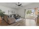 Bright living area featuring hardwood floors, comfortable seating, and a sliding door to the backyard at 13212 Briar Forest Ct, Orlando, FL 32828
