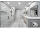 The modern bathroom features a glass shower, ample lighting, and double sinks at 13224 Casper Ln, Clermont, FL 34711