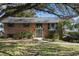 Traditional brick home featuring a well-manicured lawn, mature trees and double door entrance at 13224 Casper Ln, Clermont, FL 34711