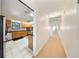 Hallway leading to kitchen, with tile flooring, wooden cabinets, and modern appliances at 13224 Casper Ln, Clermont, FL 34711