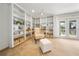 Cozy sitting area with built-in bookshelves, chair with ottoman, and natural light from the french doors at 13224 Casper Ln, Clermont, FL 34711