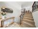 Inviting staircase with carpeted steps, iron railings, and a stylish console table at 13224 Casper Ln, Clermont, FL 34711