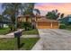 Charming two-story home with a well-manicured lawn and lush tropical landscaping at 1324 Tall Maple Loop, Oviedo, FL 32765