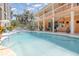 Outdoor pool area with a waterfall feature, patio, and a built-in outdoor kitchen at 1324 Tall Maple Loop, Oviedo, FL 32765