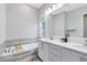Bright bathroom featuring a double vanity with marble countertops and a separate tub at 13800 Chauvin Ave, Orlando, FL 32827
