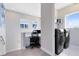 Landing area featuring a desk, and a view to the laundry room with modern washer and dryer at 13800 Chauvin Ave, Orlando, FL 32827
