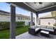 The covered patio includes a modern cushioned outdoor sofa and a sleek glass-top coffee table at 13800 Chauvin Ave, Orlando, FL 32827
