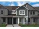 Charming townhome exterior with vertical siding, columns, and well-manicured landscaping at 13809 Luna Harvest Ave, Winter Garden, FL 34787