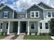 Charming two-story townhome featuring a covered porch, lush landscaping, and a welcoming entrance at 13809 Luna Harvest Ave, Winter Garden, FL 34787
