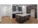 Modern kitchen featuring dark cabinetry, a large island with quartz countertops, and stainless steel appliances at 13809 Luna Harvest Ave, Winter Garden, FL 34787