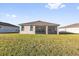 Large, grassy backyard with screened-in porch and views of surrounding houses at 1452 Hopedale Pl, Sanford, FL 32771