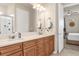 Double vanity with wood cabinets and stone countertop in this well-lit bathroom at 1452 Hopedale Pl, Sanford, FL 32771