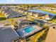 Aerial view of a community pool and clubhouse surrounded by residential homes and a large pond on a sunny day at 1452 Hopedale Pl, Sanford, FL 32771