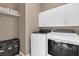 Laundry area featuring white cabinets, Whirlpool washer and dryer, and storage shelves at 1452 Hopedale Pl, Sanford, FL 32771