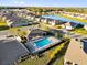 Aerial view of community pool with lounge seating, adjacent parking, and nearby pond at 1452 Hopedale Pl, Sanford, FL 32771