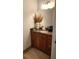 Bathroom vanity featuring wood cabinets, granite counters, and a decorative mirror at 150 E Robinson St # 12A-15 / 1216, Orlando, FL 32801