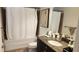 Bathroom with a white shower curtain, dark vanity, granite counters, and modern fixtures at 150 E Robinson St # 12A-15 / 1216, Orlando, FL 32801