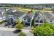 Aerial view of a modern residence overlooking a golf course, featuring a dark roof, and manicured landscaping at 1543 Corolla Ct, Reunion, FL 34747