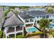 Home aerial view showcases the pool and spa, covered patio, and landscaping at 1543 Corolla Ct, Reunion, FL 34747