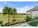 Expansive golf course view from the balcony, framed by palm trees and lush landscapes at 1543 Corolla Ct, Reunion, FL 34747