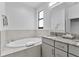 Bright bathroom featuring a large soaking tub, granite countertops, and modern lighting at 1543 Corolla Ct, Reunion, FL 34747