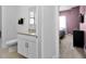 Clean bathroom with granite counters and a view into a bedroom, perfect for guests at 1543 Corolla Ct, Reunion, FL 34747