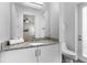Bathroom with granite countertop, white vanity, toilet, and access to the bedroom at 1543 Corolla Ct, Reunion, FL 34747