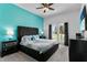 Beautiful bedroom featuring a turquoise accent wall, fan, french doors, and well-coordinated decor at 1543 Corolla Ct, Reunion, FL 34747