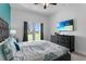 Well-lit main bedroom offering access to the back yard, large TV, and stylishly coordinated decor at 1543 Corolla Ct, Reunion, FL 34747