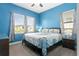 Bright bedroom featuring blue walls, a queen bed, and abundant natural light from two windows at 1543 Corolla Ct, Reunion, FL 34747