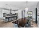 Modern kitchen with stainless steel appliances, white cabinets, long island with seating, and elegant light fixtures at 1543 Corolla Ct, Reunion, FL 34747