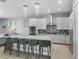 The island kitchen features granite counters, pendant lighting, stainless appliances, and barstool seating at 1543 Corolla Ct, Reunion, FL 34747