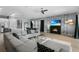 Open-concept living space with a modern fireplace, view of the kitchen, and a large sectional sofa at 1543 Corolla Ct, Reunion, FL 34747