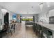 Open-concept living space featuring a modern kitchen, living room, and dining area, all with a view of the outdoor patio at 1543 Corolla Ct, Reunion, FL 34747