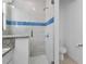 Detailed view of the walk-in shower featuring decorative tile and modern fixtures at 1543 Corolla Ct, Reunion, FL 34747