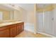 Bright bathroom featuring dual sinks, vanity with wood cabinets and glass shower enclosure at 16217 Saint Augustine St, Clermont, FL 34714