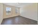 Bright bedroom with wood-look floors, two windows, and neutral walls at 16217 Saint Augustine St, Clermont, FL 34714