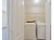Compact laundry room with a front-load washer, dryer, and storage shelf at 16217 Saint Augustine St, Clermont, FL 34714