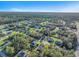 Aerial view of a residential community surrounded by lush green forests and clear blue skies on a sunny day at 17135 Sw 41 Ct, Ocala, FL 34473