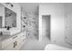 Bright bathroom featuring a marble tiled shower, white cabinets, dual sink vanity and marble flooring at 17135 Sw 41 Ct, Ocala, FL 34473