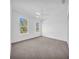 Bright bedroom with plush carpet, ceiling fan, and windows offering outdoor views at 17135 Sw 41 Ct, Ocala, FL 34473