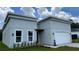 Contemporary home features a two car garage, manicured landscaping, and a light grey exterior at 17135 Sw 41 Ct, Ocala, FL 34473