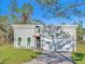 New construction home with a light gray exterior, black trim, and a brick paver driveway at 17135 Sw 41 Ct, Ocala, FL 34473