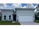 Modern two-story home featuring a gray exterior, attached two-car garage, and manicured front lawn at 17135 Sw 41 Ct, Ocala, FL 34473