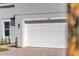 Close-up of a modern home garage door with brick driveway, lawn and accent plants at 17135 Sw 41 Ct, Ocala, FL 34473