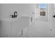Clean laundry room with a utility sink, window, and marbled tile floor at 17135 Sw 41 Ct, Ocala, FL 34473