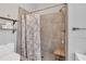 This renovated bathroom features a tiled shower, rainfall showerhead, and a comfortable wooden stool at 1817 Snaresbrook Way, Orlando, FL 32837